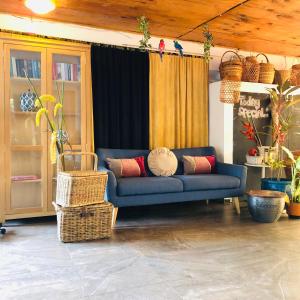 eine blaue Couch in einem Wohnzimmer mit Körben in der Unterkunft Holland Lodge Paramaribo in Paramaribo