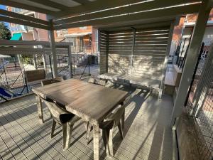 un tavolo in legno su una veranda riparata con panchina di Il Parco Di Yuki (2) ad Ancona