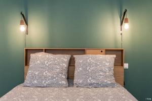 ein Schlafzimmer mit einem Bett mit zwei Kissen und zwei Lichtern in der Unterkunft LE DANDY - T2 CENTRE HISTORIQUE in Agen