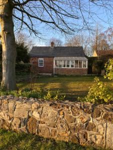 a brick house with a tree and a stone wall at The Green House in Horncastle