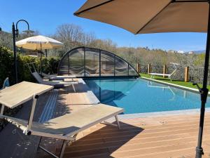 einen Pool mit Liegestühlen und einem Sonnenschirm in der Unterkunft Casa di Campagna Pianelli in Pergine Valdarno