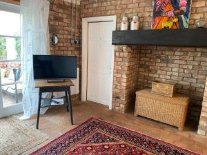 un soggiorno con TV e camino in mattoni di The Green House a Horncastle
