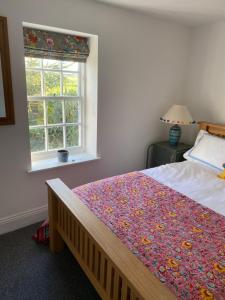 una camera da letto con un letto con una coperta a fiori e una finestra di The Green House a Horncastle