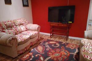 uma sala de estar com 2 sofás e uma televisão de ecrã plano em Ocho Rios Hideaway em Ocho Rios