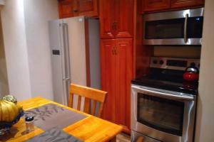 a kitchen with a table and a stainless steel refrigerator at Ocho Rios Hideaway in Ocho Rios +3 photos