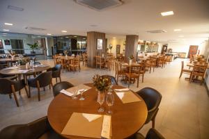 a restaurant with wooden tables and chairs and tables and chairsktop at Hotel da Costa By Nobile in Aracaju