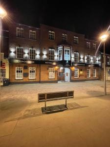 a bench in front of a building at night at Gainsborough Hotel in Gainsborough