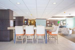a restaurant with a table and chairs in a cafeteria at Holiday Inn & Suites Spring - The Woodlands in Spring