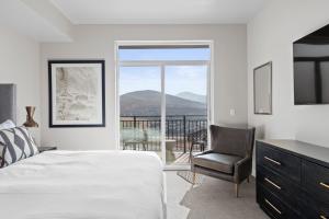 a bedroom with a bed and a chair and a balcony at Black Rock Mountain Resort in Park City