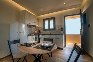 a kitchen with a table with chairs and a refrigerator at Villa Margarita Suites in Hersonissos