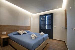 ヘルソニソスにあるVilla Margarita Suitesのベッドルーム1室(ブルーベッド1台、タオル付)
