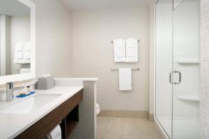 een witte badkamer met een wastafel en een douche bij Holiday Inn Express & Suites Kingsland I-95-Naval Base Area, an IHG Hotel in Kingsland