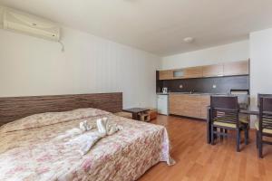 a bedroom with a bed and a table and a kitchen at Guest Apartments Co Morenia in Sunny Beach