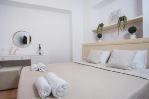 a white bedroom with a bed with towels on it at Kamara Antica Apartments in Rhodes Town
