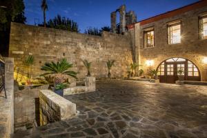 an exterior view of a stone building with a courtyard at Kamara Antica Apartments in Rhodes Town