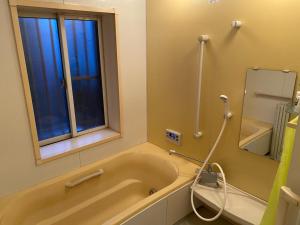 baño con bañera y ventana en Ise Toyohama Villa - Vacation STAY 11133 en Ise