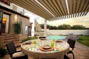 un patio con tavolo, sedie e piscina di Villa Alcantara a Graniti