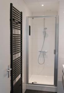 eine Dusche mit Glastür im Bad in der Unterkunft State Klaver Vier in Hollum