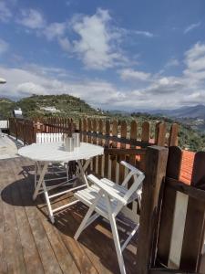 une table et des chaises blanches sur une terrasse en bois dans l'établissement Bungalow Sixdays 3, à Camporosso