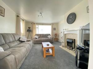 a living room with a couch and a fireplace at Copthorne - Tintagel in Tintagel