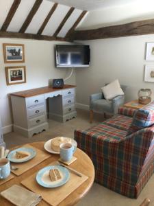 a living room with a table with food on it at The Byre at Heartwood in Ticehurst