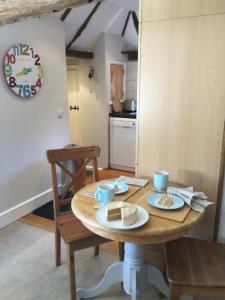 a table with two slices of cake on it in a kitchen at The Byre at Heartwood in Ticehurst +2 photos