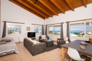 a living room with a table and chairs and windows at Plaque Panoramic SeaView Villa in Chania Town