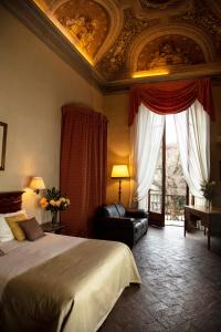 a bedroom with a bed and a couch and a ceiling at Hotel Palazzo Guadagni in Florence