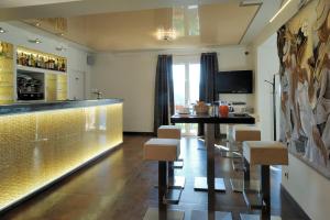 a bar in a room with a counter and stools at Hotel Des Roches in Sartène