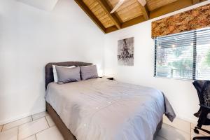 a white bedroom with a bed and a window at Poolside Getaway Permit# 4610 in Palm Springs +27 photos