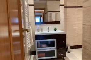 a bathroom with a sink and a tv on a counter at Apartamento Miramar . Amplitud y Comodidad in Almazora