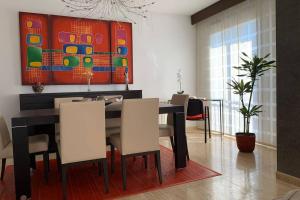 a dining room with a table and chairs and a painting at Apartamento Miramar . Amplitud y Comodidad in Almazora