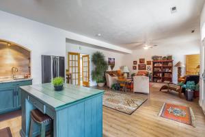 a kitchen with blue cabinets and a living room at Sunny Cozy Condo in St. George