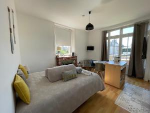 a living room with a bed and a desk and window at Résidence Le Roc Fleuri in Saint Malo