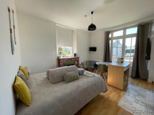 - un salon avec un lit, un bureau et une fenêtre dans l'établissement Résidence Le Roc Fleuri, à Saint-Malo