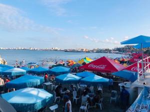 people sitting under umbrellas on a beach with the water at Hotel San Angel Cerca Del Acuario in Veracruz