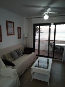 sala de estar con sofá y mesa en Primera linea de playa "Barrosamar", en Chiclana de la Frontera