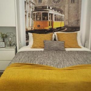 1 dormitorio con 1 cama grande y una pintura de tranvía en Studio 63 Historic Center, en Lisboa