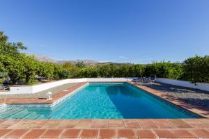 una piscina de agua azul en un patio en Casas rurales "Las Mellizas" Piscina privada - Caminito del Rey, en Álora