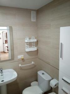 a bathroom with a white toilet and a sink at Primera linea de playa "Barrosamar" in Chiclana de la Frontera