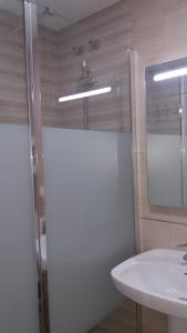 W łazience znajduje się umywalka i przeszklony prysznic. w obiekcie Primera linea de playa "Barrosamar" w mieście Chiclana de la Frontera