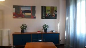 una stanza con un armadio blu con due piante in vaso di La vedetta del Montefeltro a Peglio
