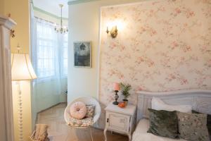 - une chambre avec un lit et un mur floral rose dans l'établissement Royal Residence 1901, à Sinaia