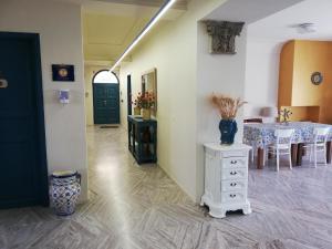 a dining room with a table and a vase on a dresser at Casale Di Benedetto in Caltagirone