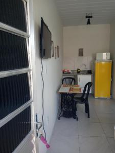 a small kitchen with a table and a yellow refrigerator at Loft agradável em João Pessoa, PB in João Pessoa