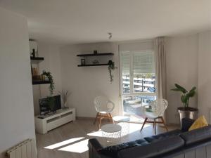 een woonkamer met een bank en stoelen en een televisie bij Luxury Apartment Accommodation, next to beach & train station Calella in Calella