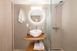 een badkamer met een wastafel en een glazen douche bij UniQApt in Corfu-stad
