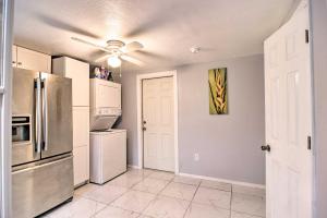 a kitchen with a refrigerator and a ceiling fan at Quaint Jungle Hideaway Near Downtown St Pete in St. Petersburg