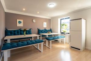 a living room with blue couches and a refrigerator at Green Valley Lounge Apartment in Weibern