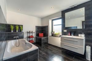 a bathroom with a large tub and a sink at Green Valley Lounge Apartment in Weibern